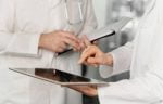Médicos conversam consultando um tablet - Crédito: Freepik